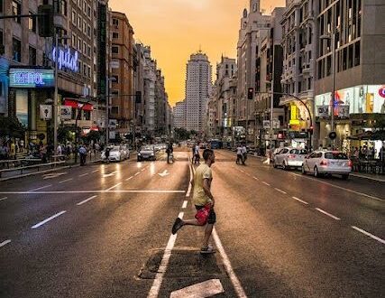 A man running across a city street during a golden sunset, showing strong photographic composition.